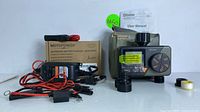 MotoPower automatic battery charger with cables and Diivoo dual water timer with user manual and accessories shown together, still in original box.
