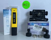 Yellow digital pH meter with its box and black self-priming drill pump with attachments on white background