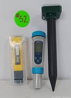 Lot showing all three devices: yellow digital pH meter in case, blue and gray TDS tester, and green solar-powered pest repeller with black stake.