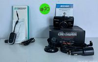Full view of the Boogio dash camera set including the camera, box, user manual, suction mount, car charger, and cables beside the J51 Bluetooth transmitter in original packaging.