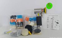 Full kit photo including pneumatic sander, assorted polishing pads, sanding discs, and instruction sheet in original arrangement