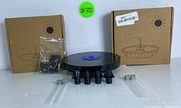 Two boxed units of solar-powered floating fountain pumps with multiple nozzle attachments and clear stakes, shown on a white background.