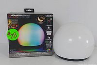 Front view of the Monster Illuminessence smart LED mood light in original retail box featuring illuminated orb graphic, brand name, size specifications, and key features.