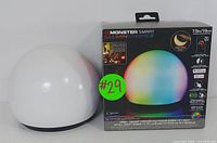 Photo of the white spherical Monster Illuminessence LED Mood Light alongside its retail packaging box labeled with features and color options.