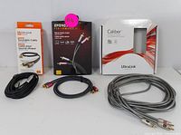 Three audio cables and their packaging displayed: Ultraklink Turntable Cable, Energy Performance II Stereo audio cable, and a loose gray Ultraklink cable.