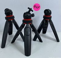 Front view of three Mobifoto tripods showing the design, red accent rings, and ball heads.