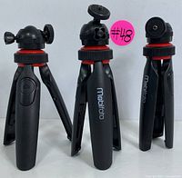 Photo of three Mobifoto tripods standing upright showing the legs and ball heads
