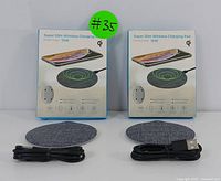 Front view of two boxed wireless charging pads side-by-side with their USB-C cables placed in front.