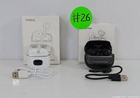 Two pairs of wireless earbuds: white POMUIC earbuds with charging case and cable on the left, black Donerton earbuds with charging case and cable on the right.