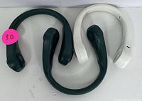 Two portable neck fans, one black and one white, laid flat on a white surface, showing overall shape and fan vent positions.