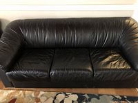 Front view of black leather 3-seater sofa showing full seating area and armrests
