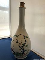 Front and side views of the porcelain vase showing floral and bird motif