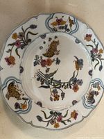 Top view of a single Haviland Golden Quail dinner plate showing detailed floral and quail pattern with scalloped gold-trimmed edge.