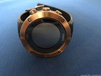 Front view of watch face with bronze bezel and black screen, showing Suunto branding.