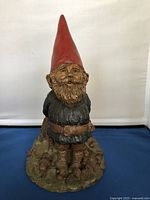 Front view of Thomas Clark Forest Gnome showing detailed facial features, red hat, and base with roots and mushrooms.