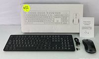 Photo showing keyboard, mouse, USB receiver, user manual, and box with keyboard and mouse illustrations.