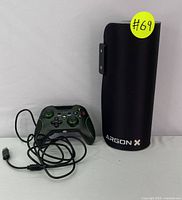 Gaming controller alongside rolled RGB mouse pad standing vertically showing Argon X brand.