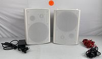 Pair of white Herdio HOS-601 speakers with front grill and power cables.
