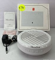 Photo of the MelodySusie nail dust collector with the power adapter, instruction manual, and original box.