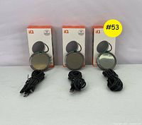 Set of three iQ USB-C magnetic wireless charging pads displayed with their original packaging and cables laid out in front.