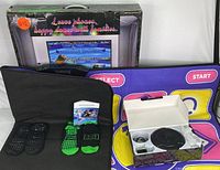 Photo displaying the dance mat game components including wireless controllers, mat, carrying case, and original box with product branding and instructions visible.