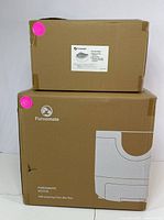 Two cardboard boxes, one larger labeled Furromate PCT110 Self-cleaning Cat Litter Box, one smaller with replacement tray label.