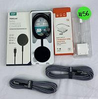 Photo of ESR HaloLock Mini wireless charger with box, USB 3.0 OTG adapter in packaging, and two coiled braided USB cables on white background.