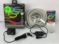 Full lot contents including box, coiled LED strip, power adapter, inline controller, mounting clips, and instruction manual shown on a white background.