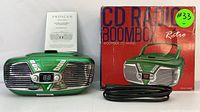 Front view of green Proscan CD Radio Boombox, digital display, chrome speaker grills, power cord, original box and instruction manual.