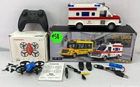 Full set laid out including the Tomzon drone, remote control ambulance and school bus vehicles, gaming controller, accessories, and packaging box.