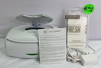 White Prince Lionheart wipe warmer with lid open, Ever-Fresh replacement pillow, power adapter, and instruction manual displayed together on white background.