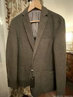 Full front view of gray wool-cotton blend men's blazer jacket on hanger with tags attached.