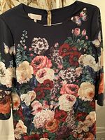 Front view of the vintage HOBBS floral print dress showing the colorful floral design with butterflies on dark background, round neckline, and three-quarter sleeves.
