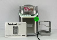 Main Cuisinart ICE-70C ice cream maker unit with instructional booklet and mixing arm on a clean surface