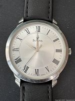 Close-up of watch face showing Bulova branding, silver dial and Roman numeral hour markers