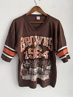 Front view of brown vintage Cleveland Browns 1994 football T-shirt with team graphic and stripes on sleeves