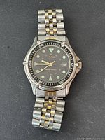 Full view of Arton men's watch showing two-tone metal band, black dial with luminous markers, and rotating bezel.