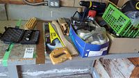 Overview of various hand tools including saws, Ryobi drill, and hardware on a workbench