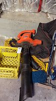 Overall view showing electric leaf blower/vacuum, hoses, extension cords, storage bin, cleaning tools and fluid.