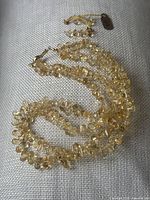 Multi-strand citrine chip necklace laid on gray fabric