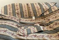 Valance and drapes laid out on surface showing striped beige, blue-grey, and cream floral damask pattern with fabric samples attached.