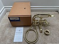 Overview of faucet assembly, coiled hose, handheld shower head, box and manual