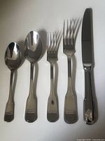 Five-piece sample showing teaspoon, soup spoon, salad fork, dinner fork and dinner knife arranged on white background