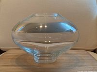 Front/side view of clear blown glass vase with polished stainless steel band and ribbed foot