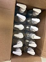 Top view of the box showing 12 bottles of Purell hand sanitizer with white pump tops.
