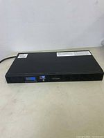 Front view of black CyberPower UPS unit showing digital blue display and power button.