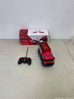 Fire rescue truck toy with remote control and original box placed on a surface