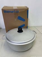 Photo of boxed Walmart.ca packaging behind the caldero pot with lid on top.