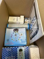 Top-down photo of box showing scattered miscellaneous household items and packaging material