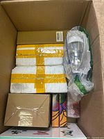 Photo of box showing various miscellaneous items packed inside including cardboard boxes, wrapped lamps, and smaller packages.